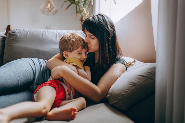 Mum kisses her kid.