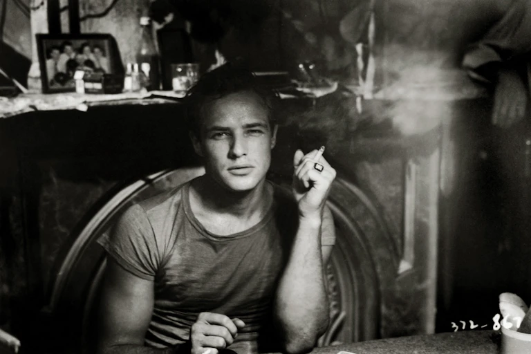 Black and white photo of Marlon Brando, smoking during the making of A Streetcar Named Desire, 1951