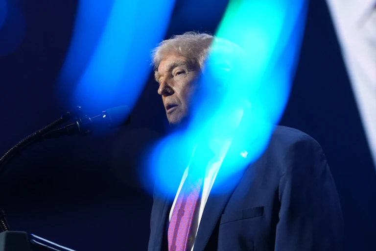 An old man's face between two beams of blue light.