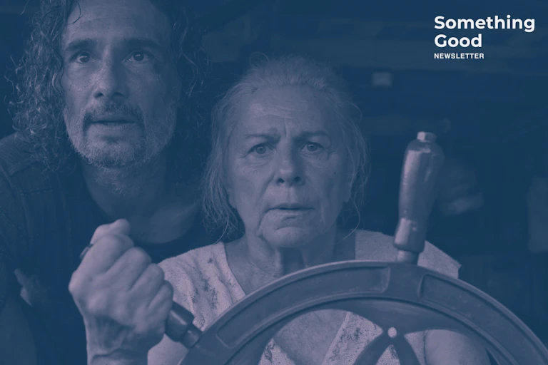 An elderly woman steering a boat