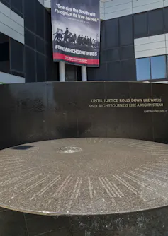 A civil rights memorial is seen in front of a banner.