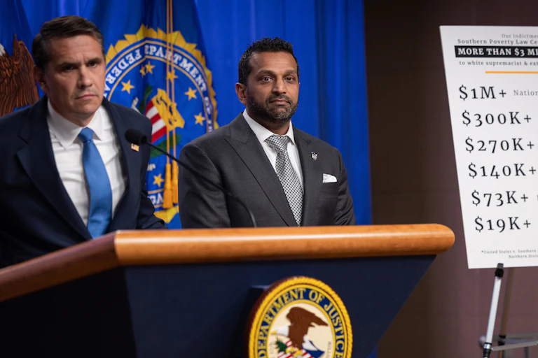 Two men stand at a lectern with an official U.S. seal emblazoned upon it.