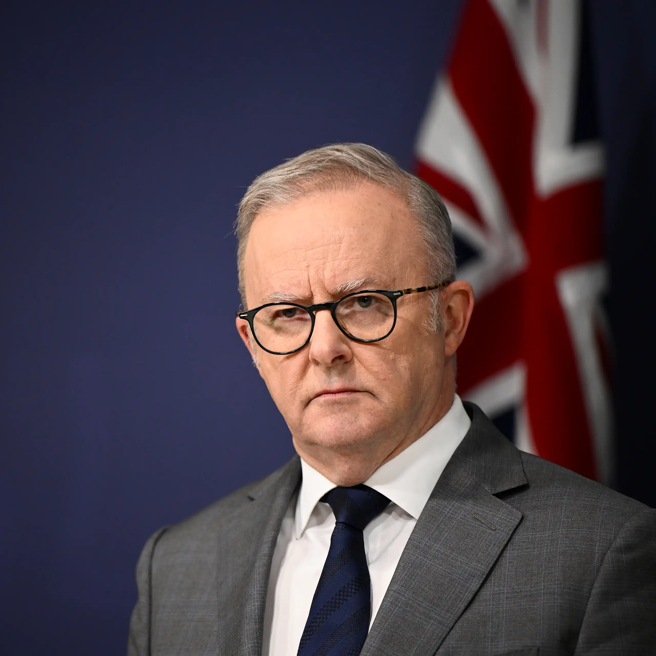 Anthony Albanese with a flag in the background