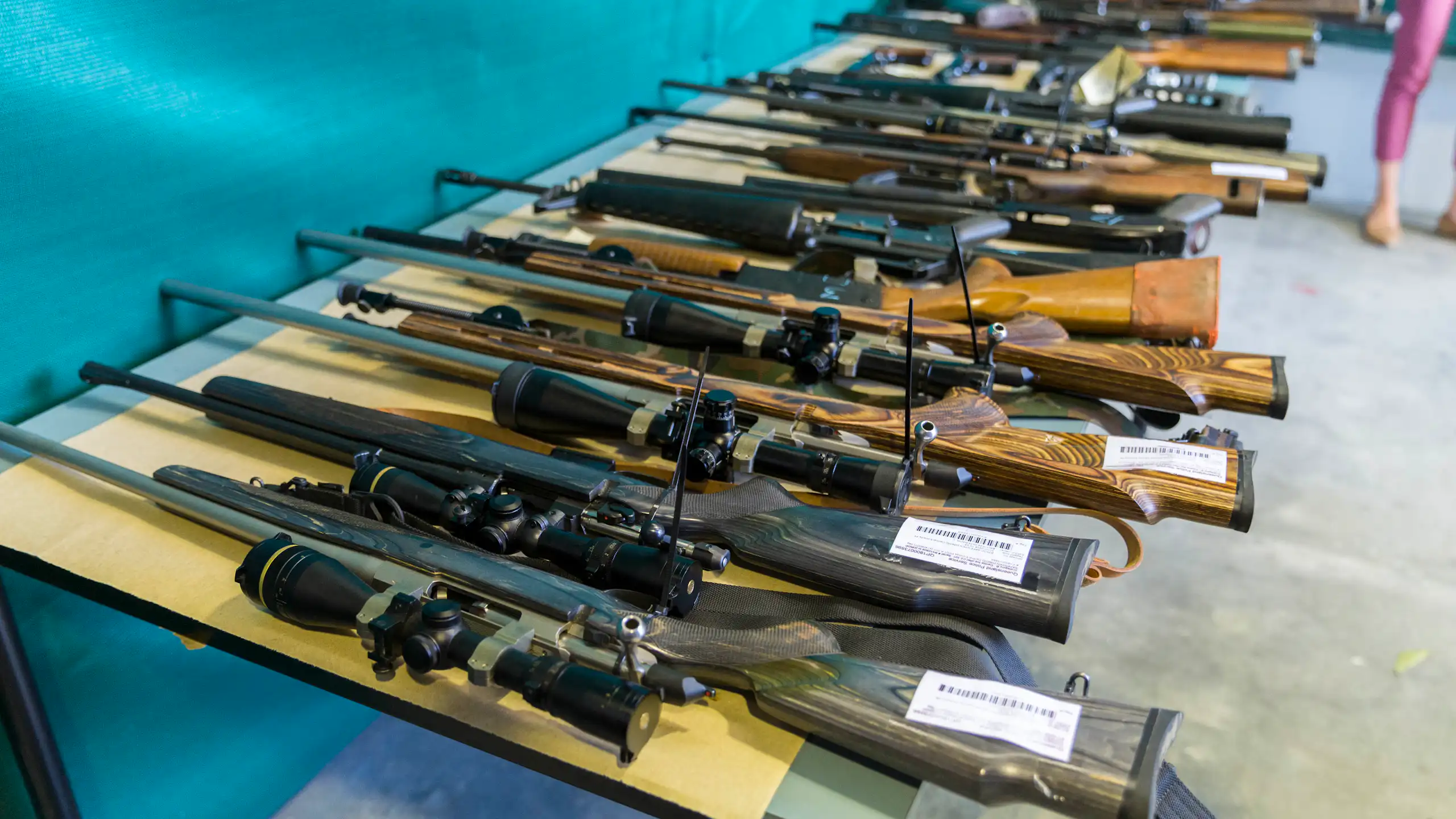 A line of large firearms lined up on a table