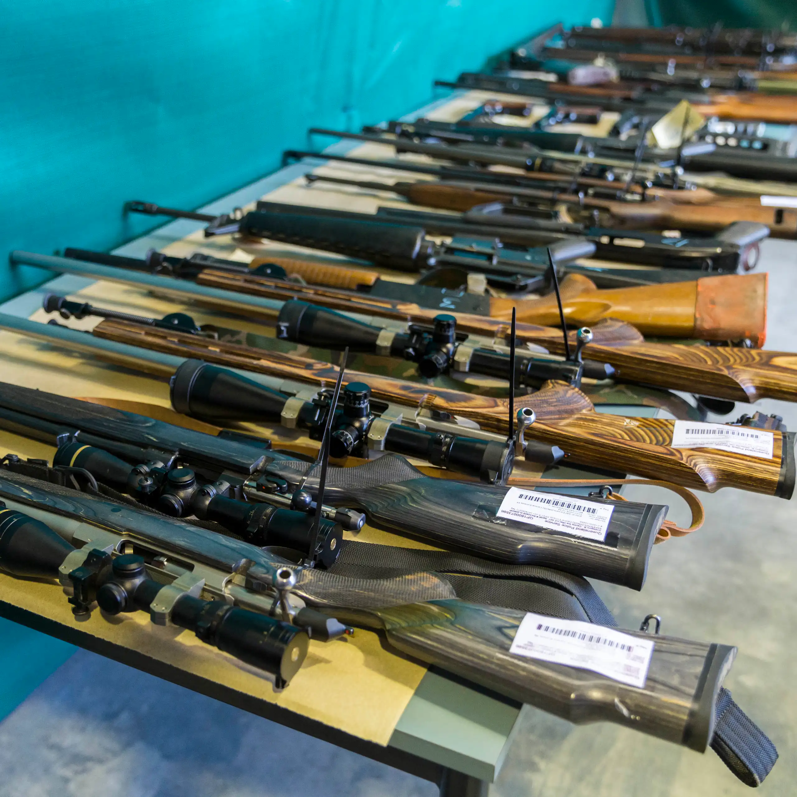 A line of large firearms lined up on a table