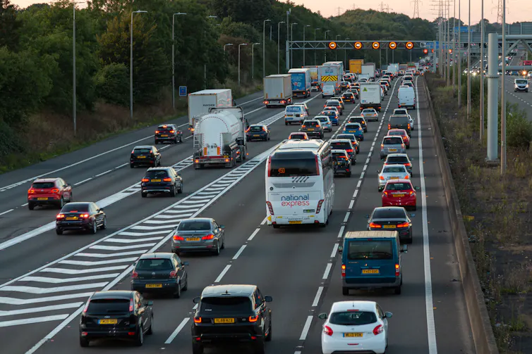 rear view of cars, coaches and lorries on a busy uk motorway at dusk