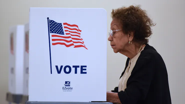 An older woman casts her ballot.