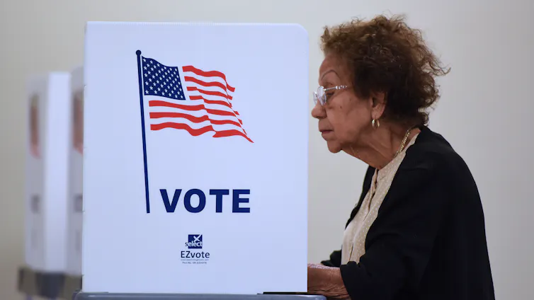 An older woman casts her ballot.