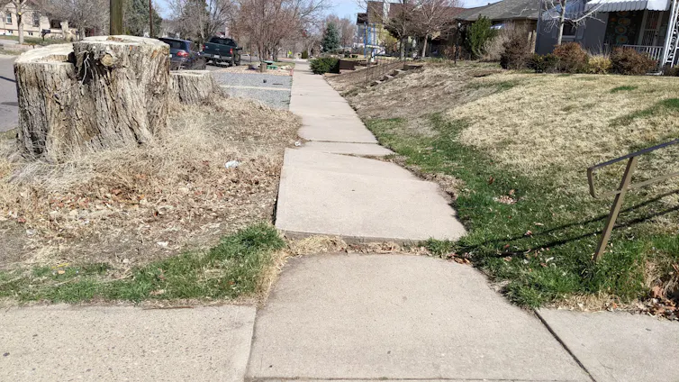 A sidewalk with a ledge where one part is raised and the other is sunken.