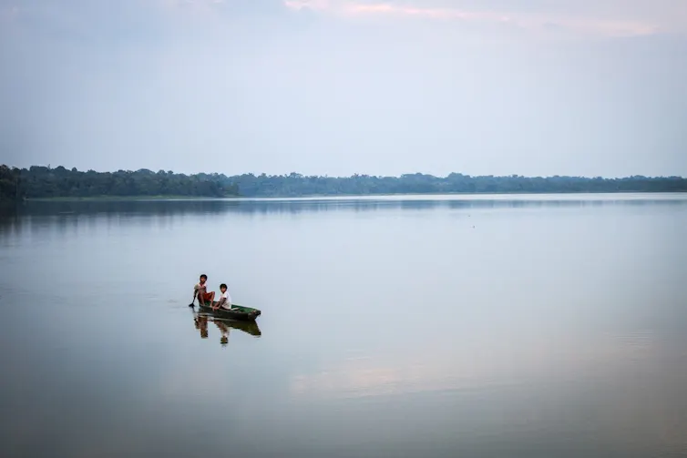 petit kayak traditionnel sur un lac calme, ciel gris