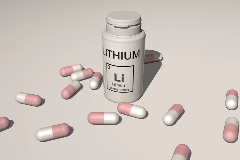 A bottle with the word ‘Lithium’ written on it, surrounded by lots of capsules.