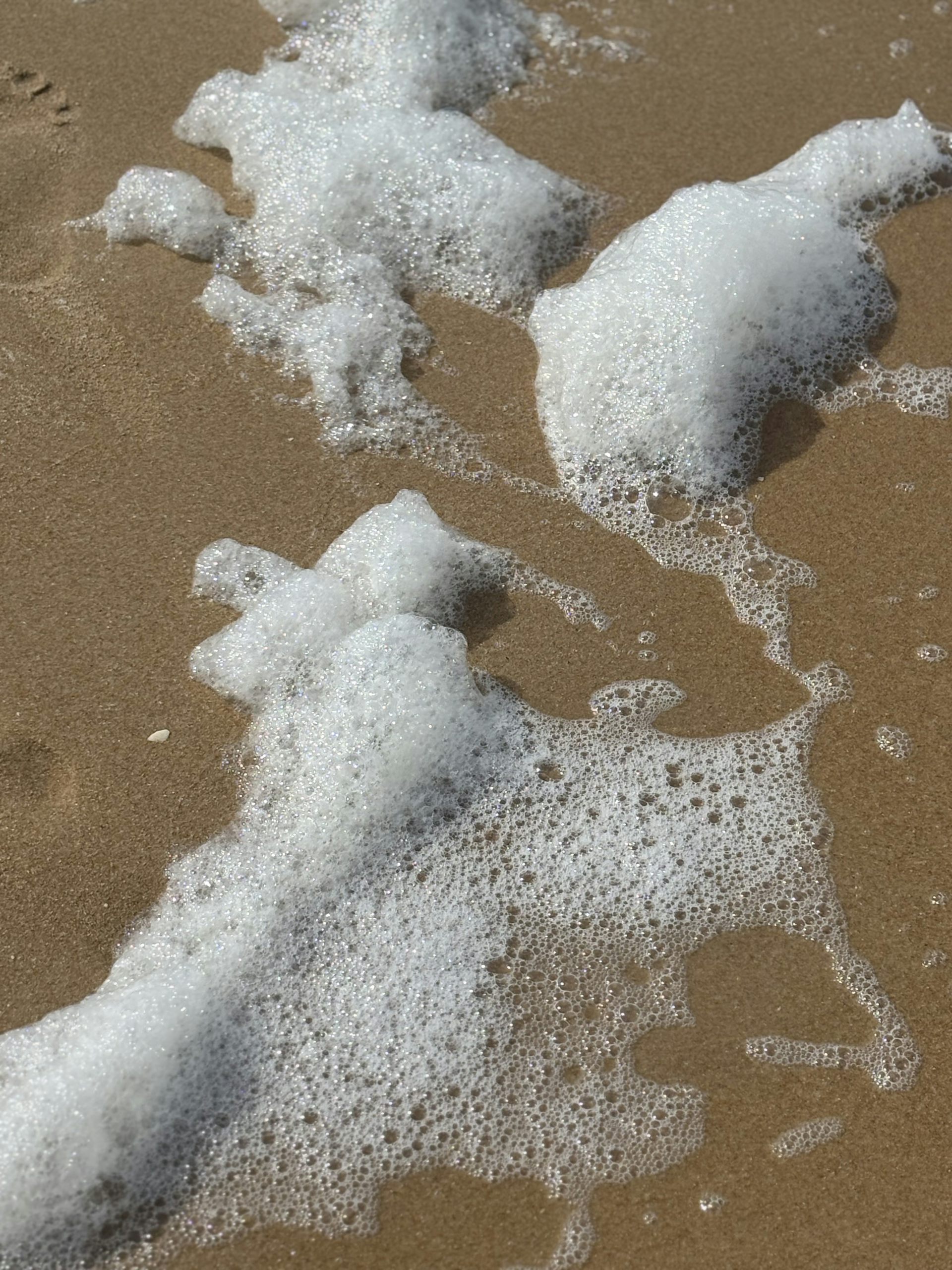 White sea foam on the sand