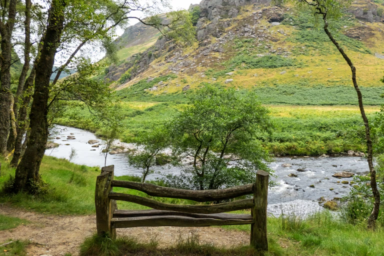 wooden bench with view over green hilly countryside landscape