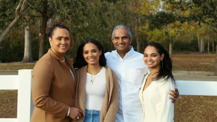 Cuando los ideales de cuidado no coinciden con la realidad en las familias de la diáspora en el sur de Asia 1 Una familia de cuatro miembros está junta al aire libre.