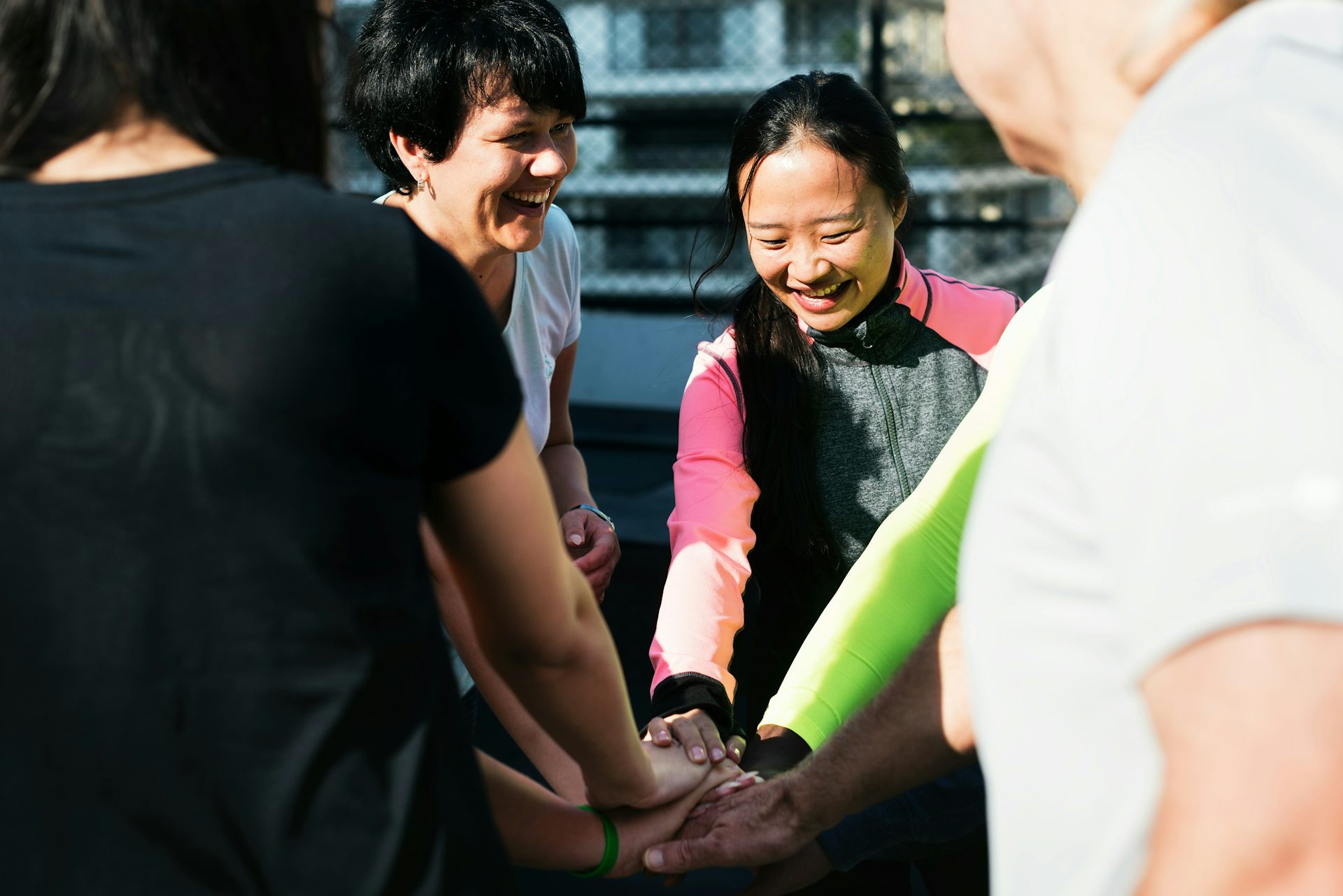 People in a circle with their hands in.