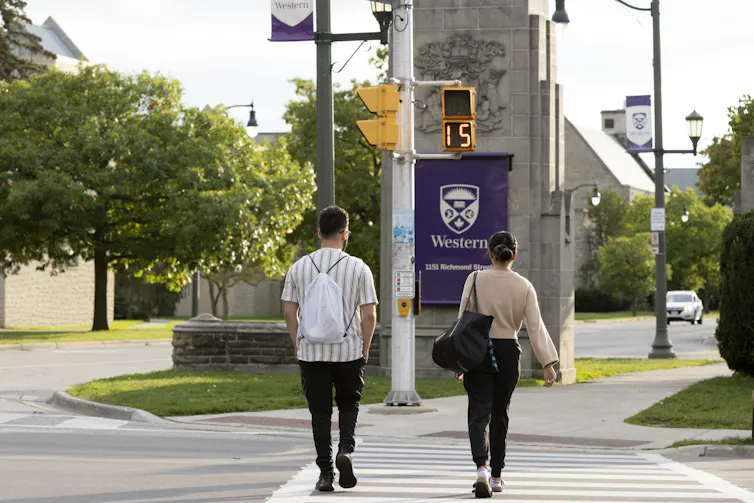 Students stand at a crosswalk.