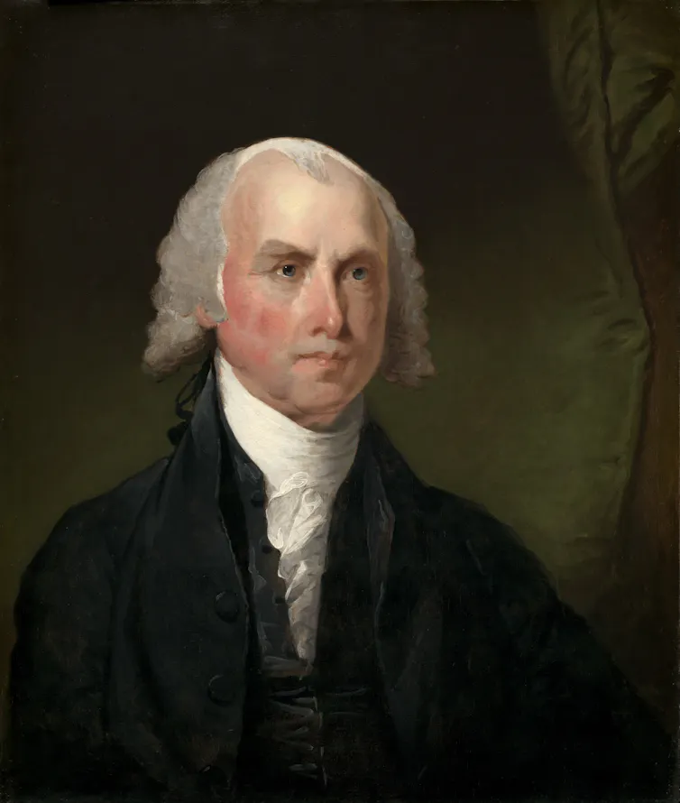 A man with rosy skin and curled white hair looks off to the distance against a dark curtain.