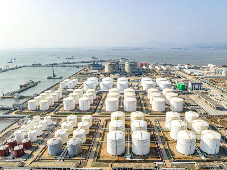 aerial view of large oil tanks next to a port.