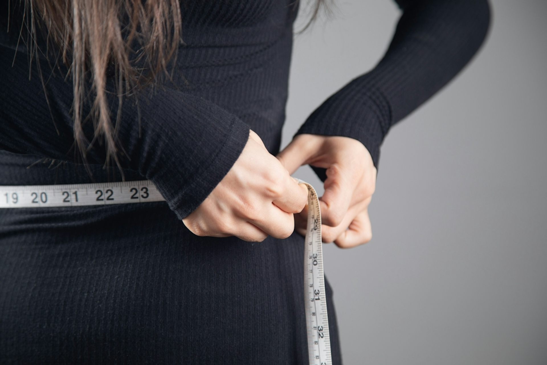 Une femme mesurant sa circonférence abdominale. 