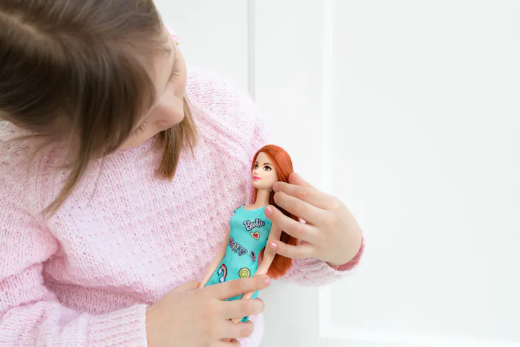 A child cuddles a doll.