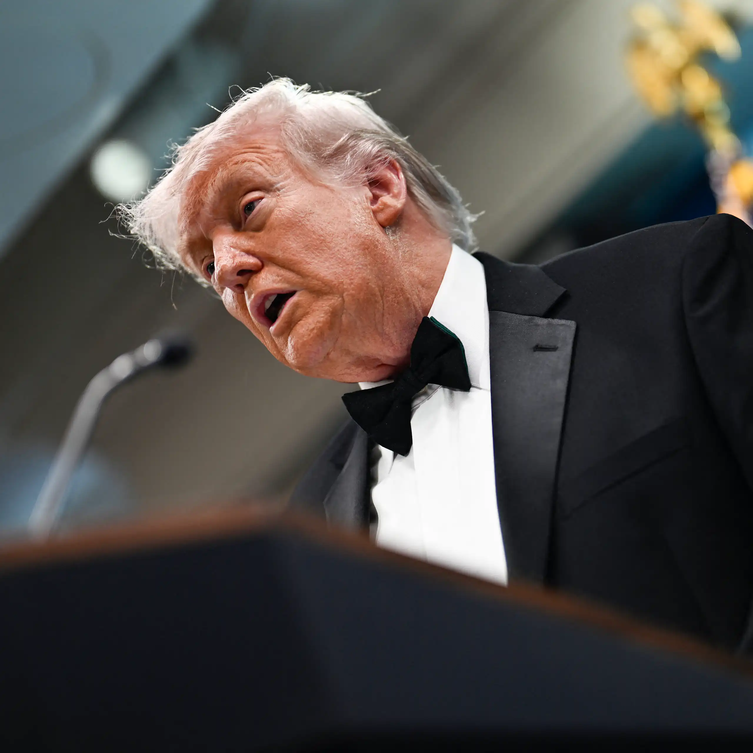 Donald Trump en contre-plongée, qui parle devant un pupitre.