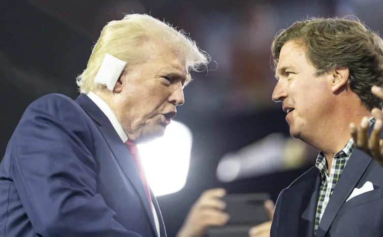 Trump speaks with Carlson at the Republican National Convention.
