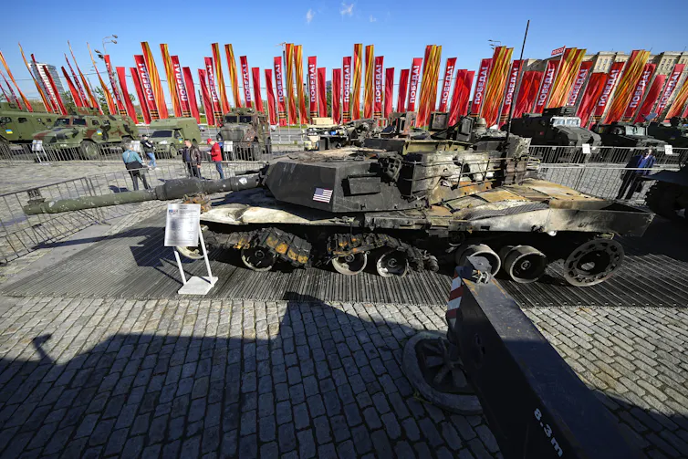 A tank is seen on display in a city square.
