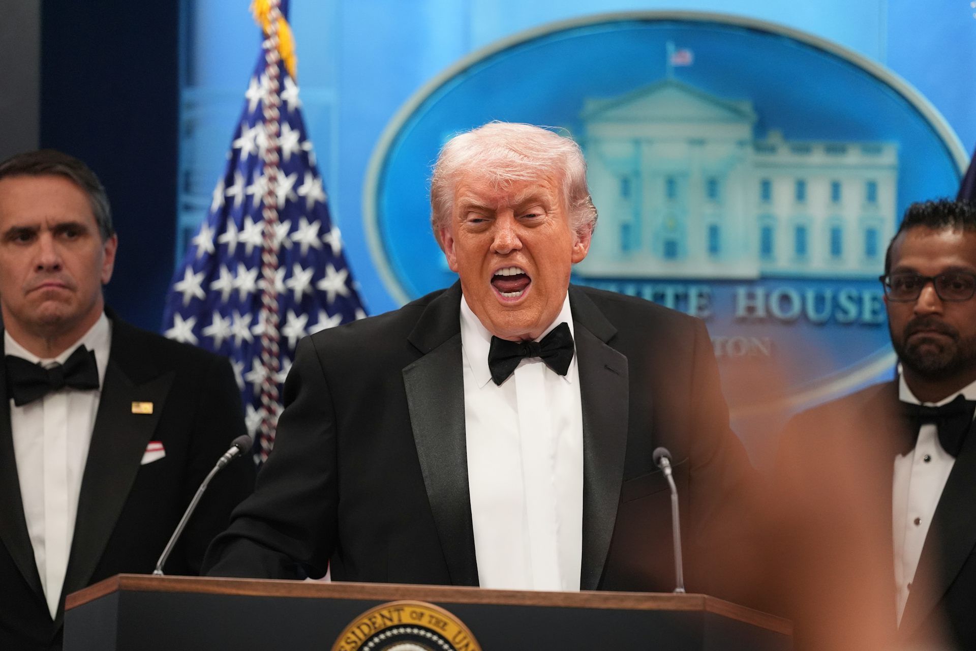 Un Donald Trump grimaçant parle dans un micro
