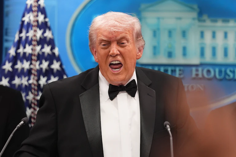 Un Donald Trump grimaçant parle dans un micro