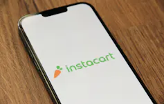 A cell phone displaying the Instacart logo
