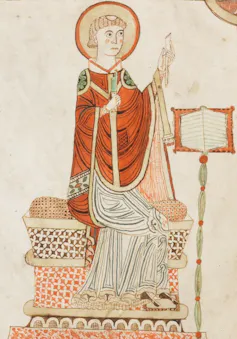 Bede as depicted in an illustrated manuscript, writing his Ecclesiastical History of the English People.