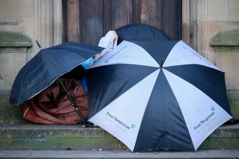 Rough sleeper den made of sleeping bag and two umbrellas