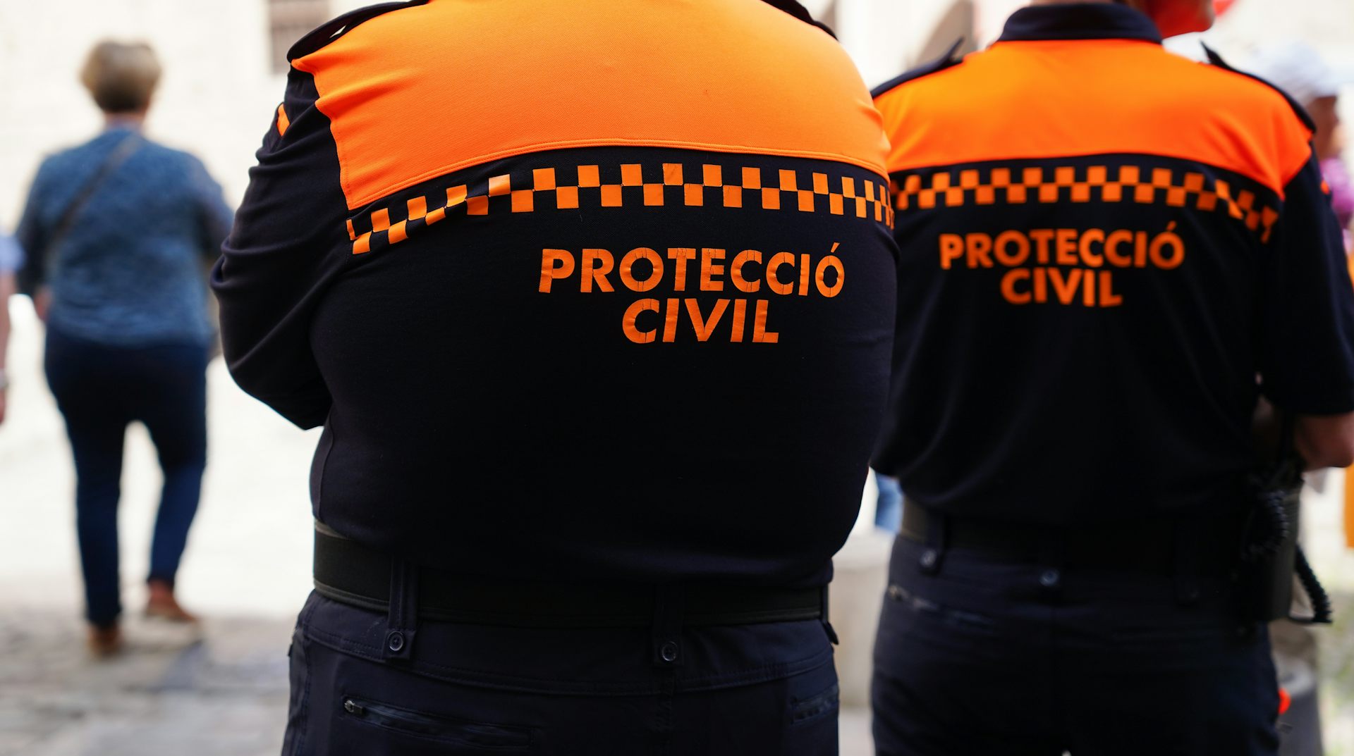 Dos tècnics de protecció civil, d'esquena.