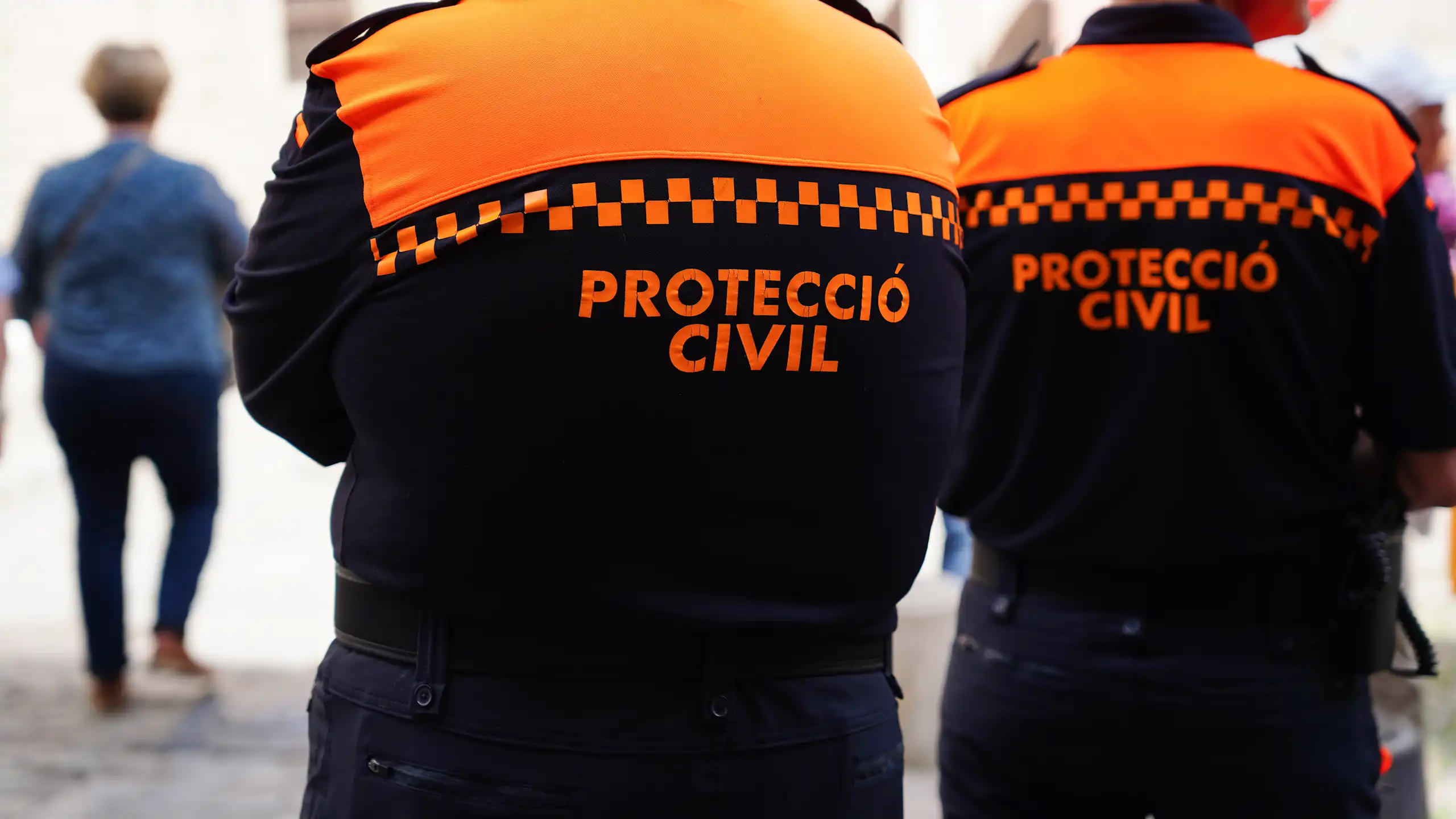 Dos tècnics de protecció civil, d'esquena.