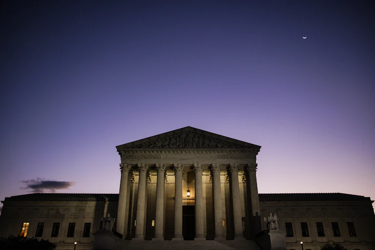 A large, columned white building in the dark.