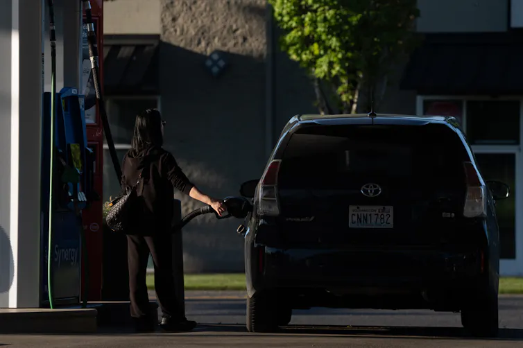 A woman fills up her car with gas.