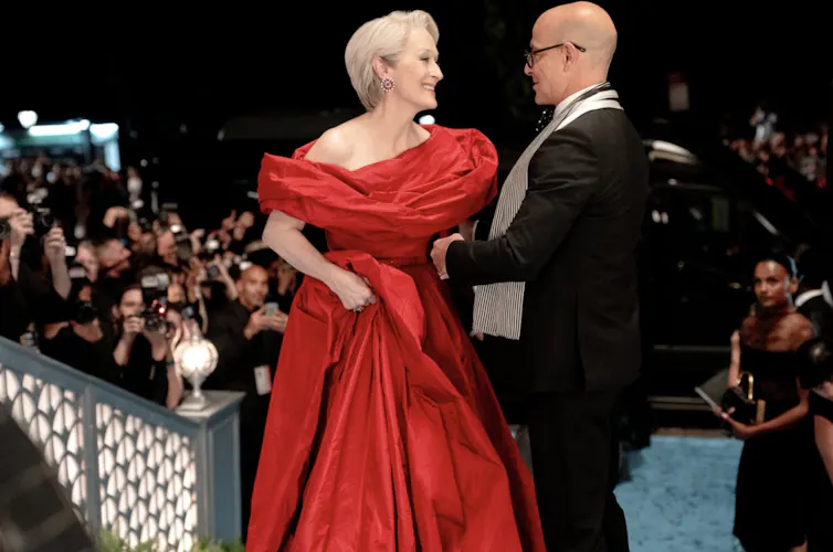 A woman in a spectacular red evening gown and a man in a tuxedo.