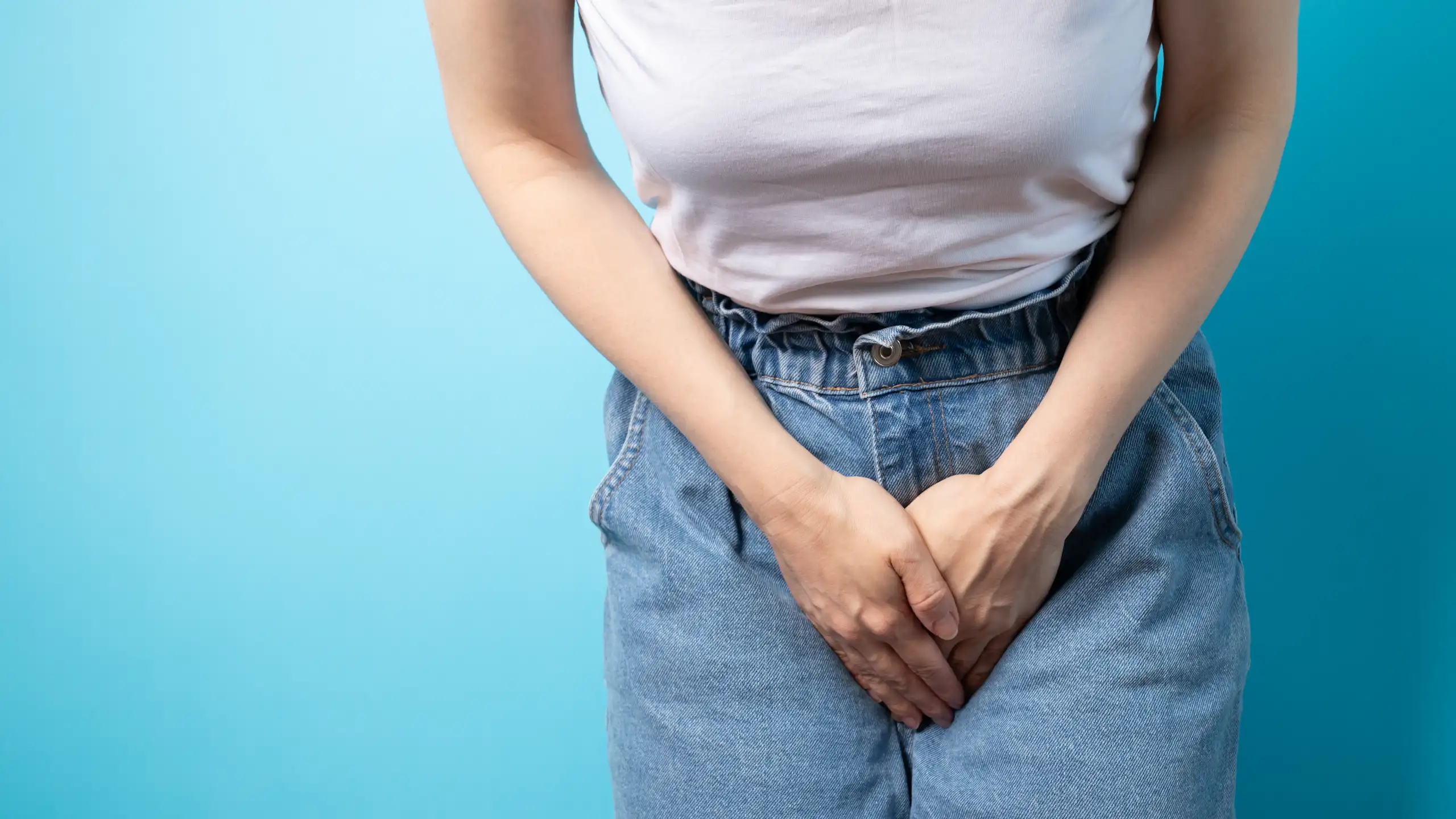 Una dona se tapa amb les mans la zona de davant del pantaló.