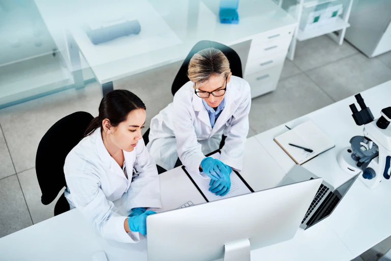Scientists at work in front of computer screen.