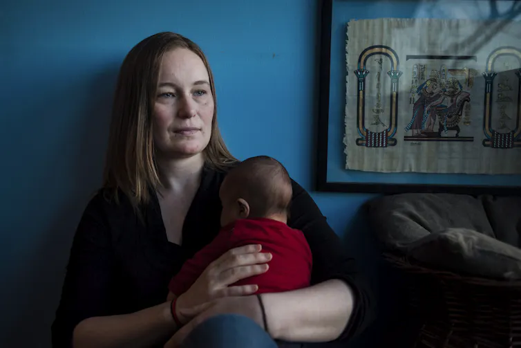 Une femme tient son bébé dans ses bras
