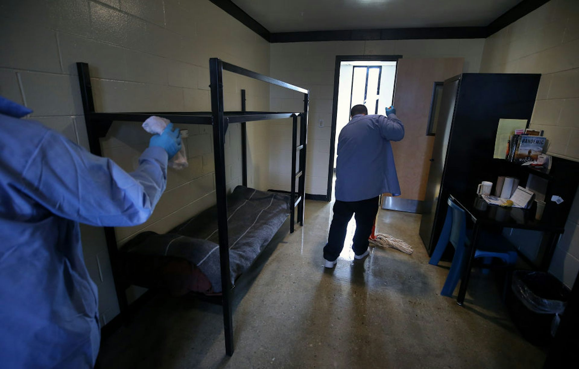 Incarcerated person mopping a jail floor.