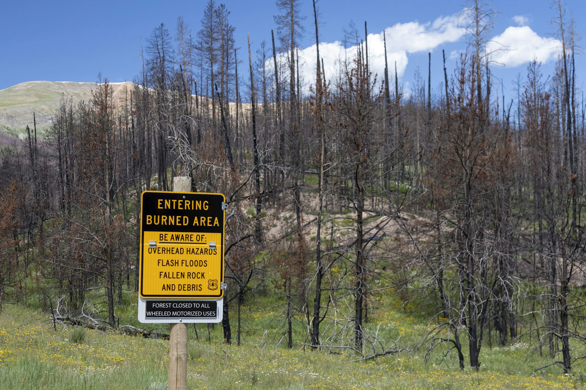 A sign says readers are entering a burned area with hazards.