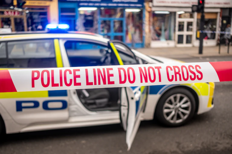Police tape and a car at a crime scene