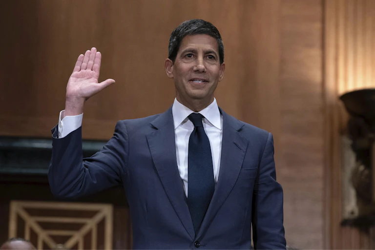 Kevin Warsh, wearing a grey suit and dark tie, is sworn in to testify at his confirmation hearing before the Senate Banking Committee on April 21, 2026.