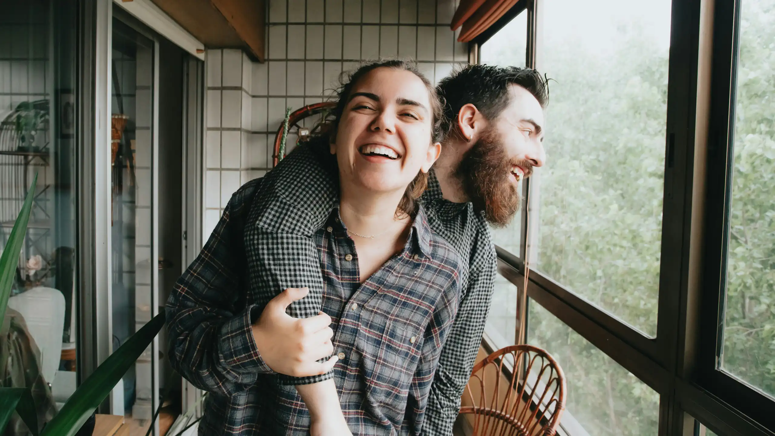 Un homme et une femme rient et s’étreignent.