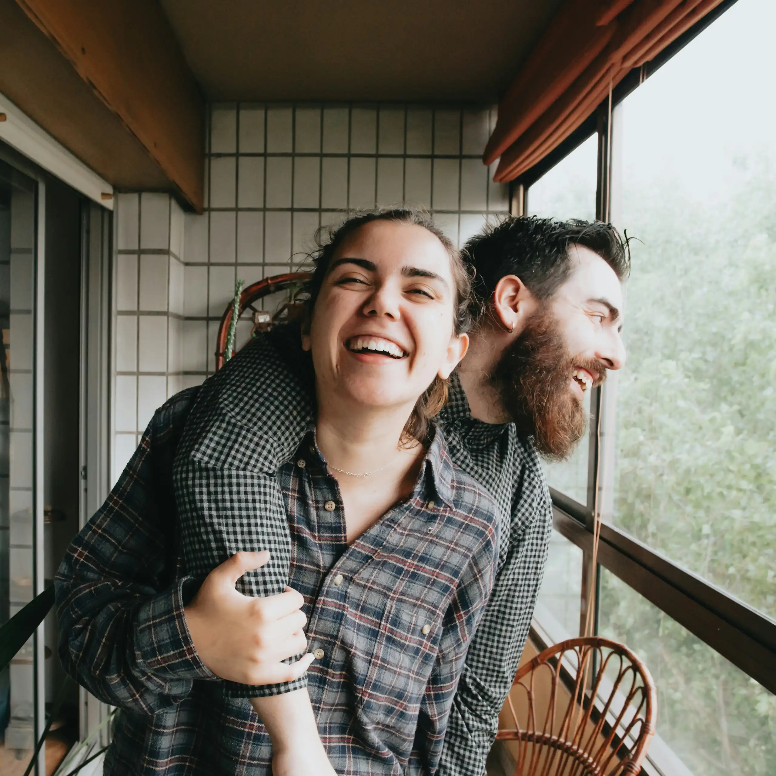 Un homme et une femme rient et s’étreignent.