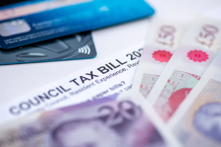 council tax bill with credit cards and bank notes.