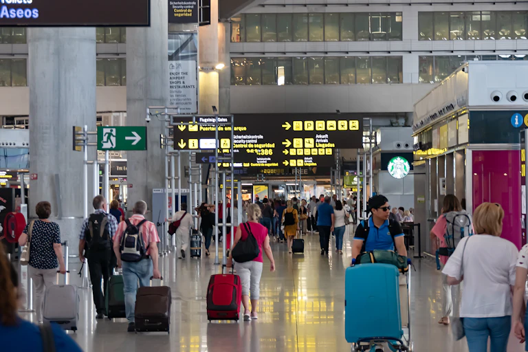 Viajeros con maletas en el interior de un aeropuerto.