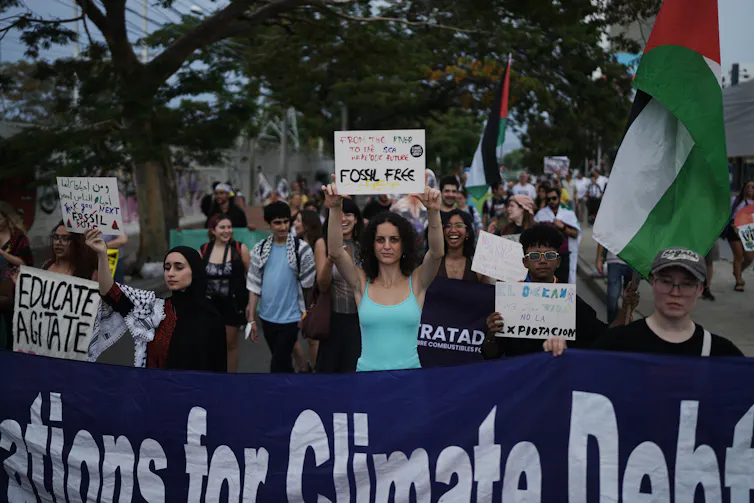 people carry placards and signs at a demonstration