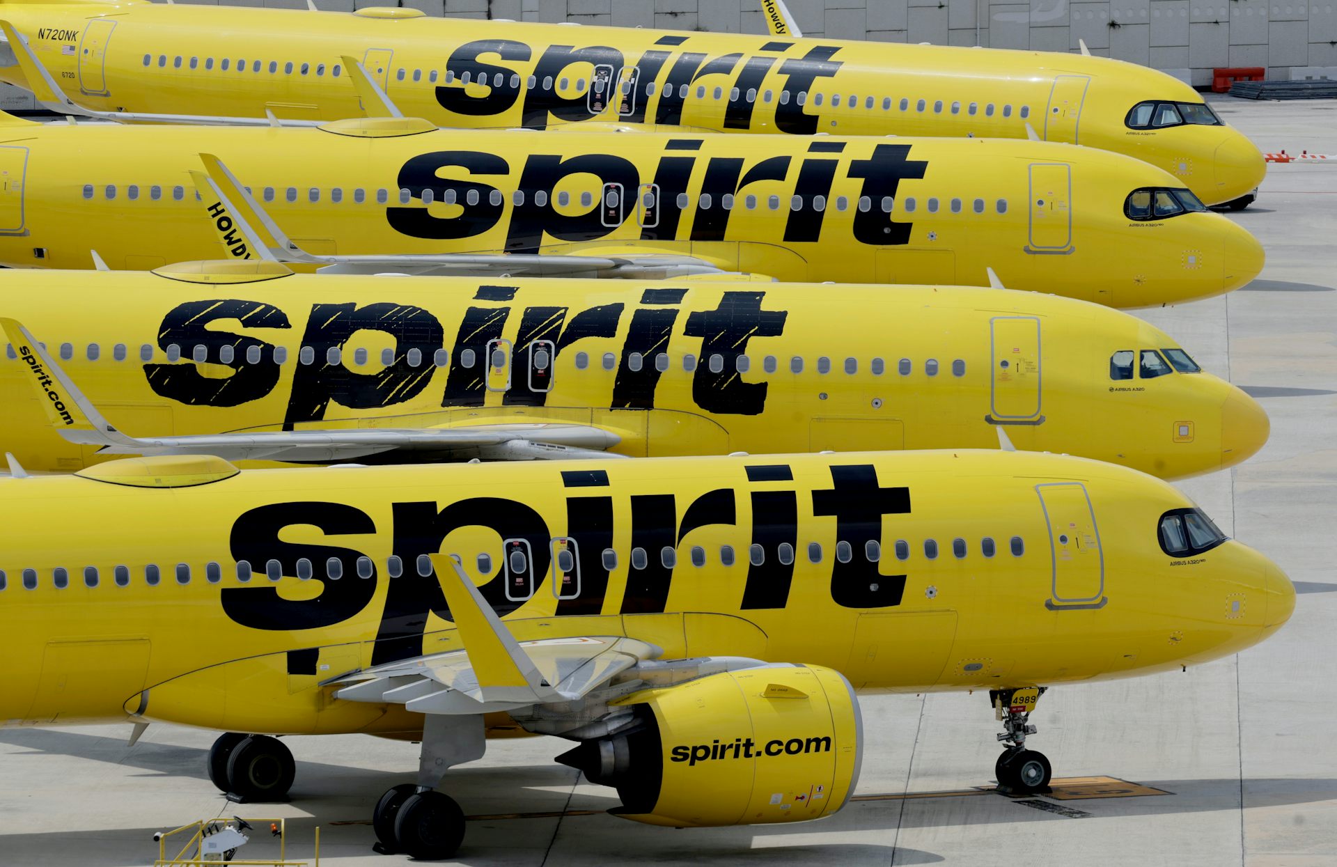Una fila de aviones amarillos sentados en la pista con la palabra fantasma escrita en el costado